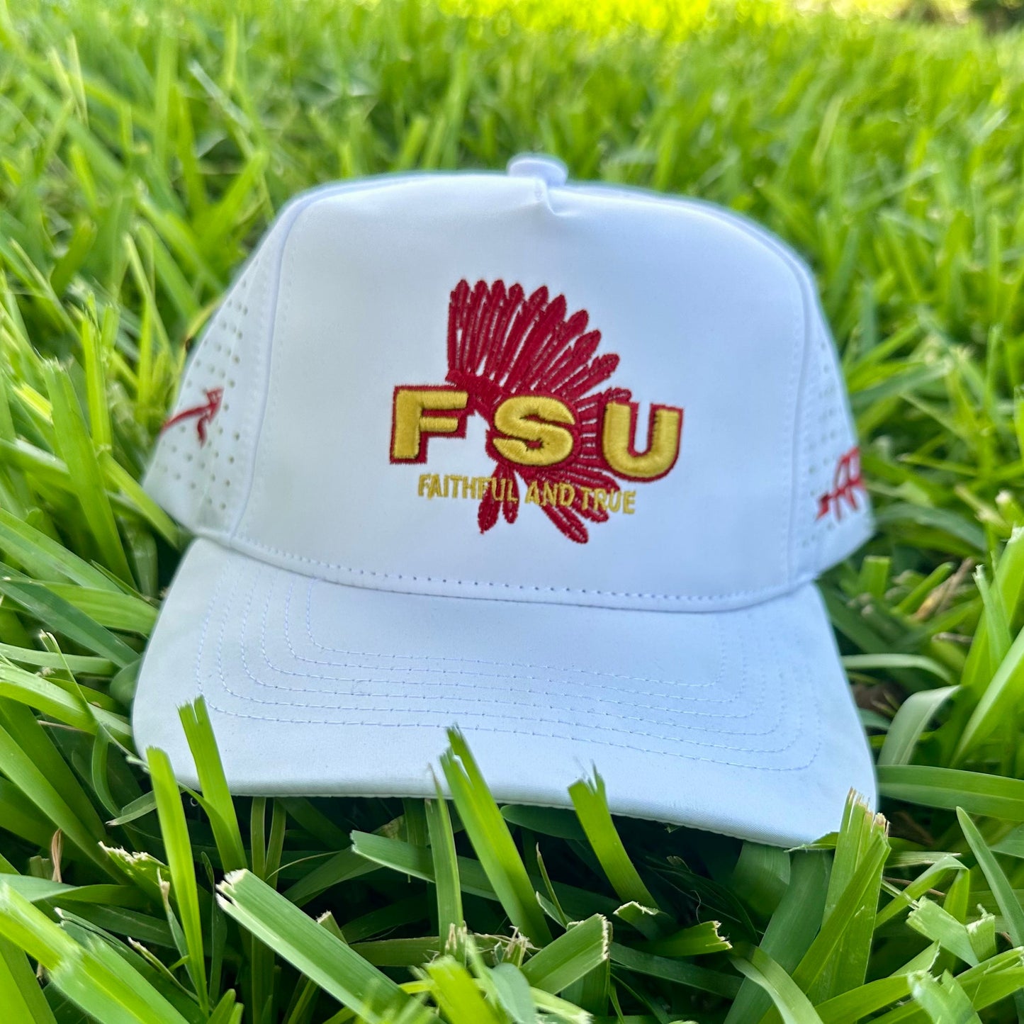White cap with FSU logo on grass